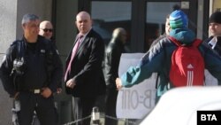 Главният прокурор Иван Гешев гледа към протестиращи в подкрепа на искането за отстраняването му пред сградата на ВСС.