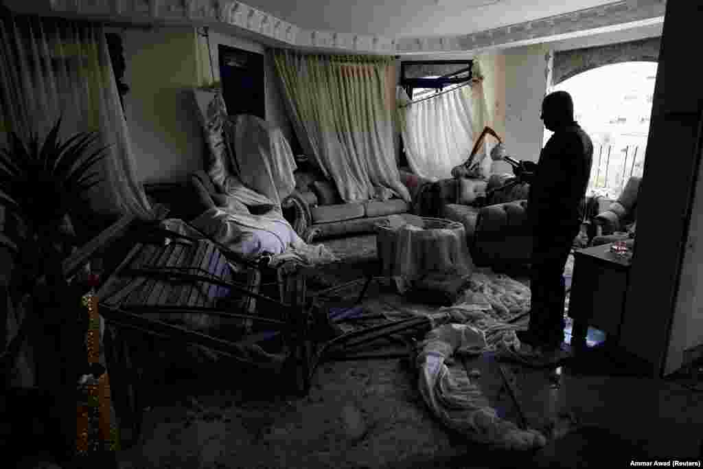 Një burrë duke qëndruar brenda një dhome të dëmtuar pasi raketa të lëshuara nga Irani goditën një ndërtesë banimi në Tamra, veri të Izraelit, më 15 qershor.