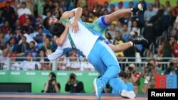 Wrestler Ikhtiyor Navruzov of Uzbekistan celebrates with his coach after winning a bronze medal.