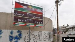 زنی در حال عبور از مقابل تابلویی در شهر غزه که روی آن نوشته شده است: «تشکر و قدردانی از ایران»