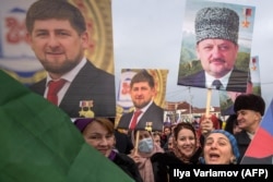 Emberek vonulnak Groznijban Ahmed Kadirov és fia, Ramzan képével 2016. január 22-én
