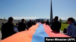 Люди несуть прапор Вірменії до меморіального комплексу Цицернакаберд, Єреван, 24 квітня 2018 року