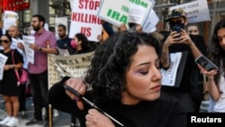 Žena u znak protesta protiv iranskog režima reže svoju kosu, New York, SAD, 27. septembar 2022.