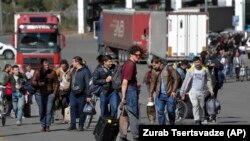 Un grup de bărbați ruși după ce au fugit din țară ca să scape de încorporare la punctul de trecere a frontierei din Verkhny Lars din Georgia. 27 septembrie 2022.