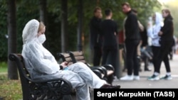 Москва шаарындагы паркта отурган коопсуздук кийимчен кыз. 