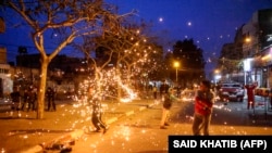 Palesztin gyerekek tűzijátékkal játszanak a Gázai övezet déli részén fekvő Rafah városában a ramadán első éjszakájának előestéjén 2022. április 1-jén