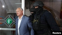 Bivši predsjednik Igor Dodon u pratnji policijskih službenika pred sudsko saslušanje u Kišinjevu u maju 2022.