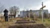 Friss sírok egy panelház mellett Bucsában 2022. április 4-én