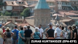 უცხოელი ტურისტების ჯგუფი ძველ თბილსში.