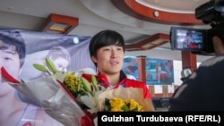 Архив сүрөт. Норвегиянын Осло шаарында өткөн күрөш боюнча Дүйнө чемпионатынан коло байге алган Айпери Медет кызын тосуп алуу учуру. 10-октябрь, 2021-ж. "Манас" эл аралык аэропорту.