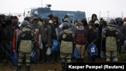 Білоруські прикордонники охороняють мігрантів біля кордону з Польщею, листопад 2021 року