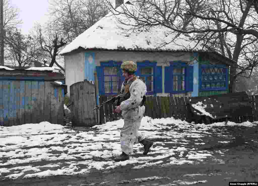 Боєць проходить повз покинутий будинок