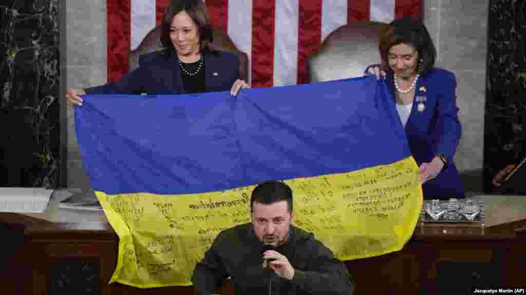Volodimir Zelenszkij kongresszusi beszéde közben Kamala Harris amerikai alelnök (balra) és Nancy Pelosi akkori házelnök mutatja azt az ukrán zászlót &nbsp;2022. december 21-én, amelyet a törvényhozóknak adott az ukrán elnök, és amelyen a Bahmutban szolgálatot teljesítő katonák aláírása szerepel