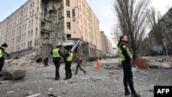 Mentők és rendőrök dolgoznak egy szállodánál, amelyet részben megsemmisített egy orosz rakétacsapás Kijev központjában 2022. december 31-én. Az orosz támadások Ukrajna több régióját célozták, köztük a fővárost, ahol a támadásoknak halálos áldozata és sebesültjei is vannak