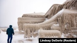 Čovjek hoda pored leda kod jezera Erie koji je prekrio restoran tokom zimske oluje, New York, SAD, 26. decembra 2022.