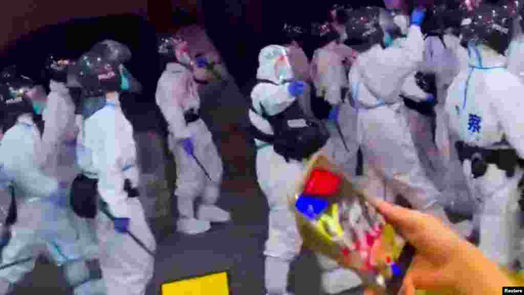 Védőruhás rohamrendőrök bevetésen a koronavírus-korlátozások miatti tüntetések során Kantonban, Kuangtung tartományban