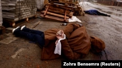 Cadavrul unui civil cu mâinile legate la spate a fost fotografiat în Bucea, pe 3 aprilie 2022, după retragerea forțelor rusești. Localnicii spun că persoana respectivă a fost împușcată de soldații ruși.