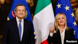 Giorgia Meloni első kormányülése kezdetét jelzi a csengővel elődje, Mario Draghi mellett a Chigi-palotában, Rómában 2022. október 23-án