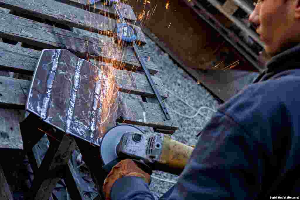 Un ucraineană polizează marginile unei plăci blindate, regiunea Zakarpattya, martie 2022.