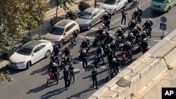 نیروهای ضد شورش در حال تیراندازی و شلیک گاز اشک‌آور به معترضان در تهران