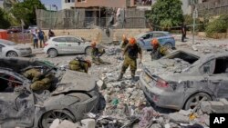 سربازان اسرائیلی در حال جستجو در ویرانه‌های برجا مانده از حملهٔ موشکی ایران به بئرشبع در روز سه‌شنبه که چندین کشته برجا گذاشت