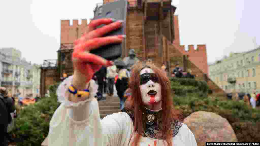 Дівчина в костюмі робить селфі на фоні Золотих воріт