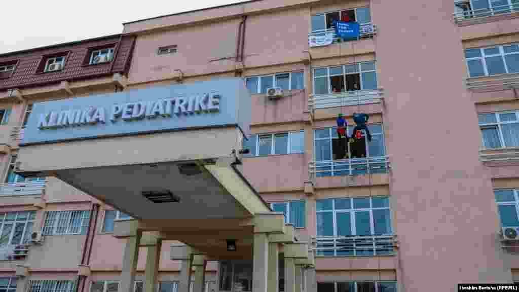 Dy alpinistë të veshur si mjekë lëshohen me litarë dhe argëtojnë fëmijët në Klinikën e Pediatrisë në Prishtinë.&nbsp;