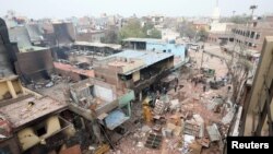 Men remove debris following clashes between people demonstrating for and against a new citizenship law in New Delhi on February 27. REUTERS/Rupak De Chowdhuri