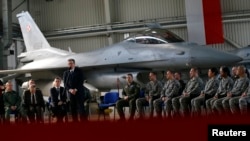 Amerikai és lengyel katonák hallgatják Bronislaw Komorowski volt lengyel elnök beszédét a Lask légitámaszponton, 2014. március 11-én