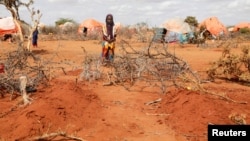 Kafia Noor (5) kod grobova svojih sestara bliznakinja Eble i Abdije koje su umrle od gladi u kampu za interno raseljene u regionu Gedo u Somaliji, 24. maj 2022.