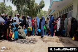 Familiile strămutate din zonele în care se desfășoară lupte între forțele de securitate afgane și talibani așteaptă ajutor în timp ce locuiesc în adăposturi temporare în Kandahar, 4 august 2021