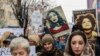Kosovo -- Women hold posters as they take part in a march for women's rights and freedom in solidarity with the march organised in Washington, on January 21, 2017 in Pristina. Hundreds of thousands of protesters spearheaded by women's rights groups are 