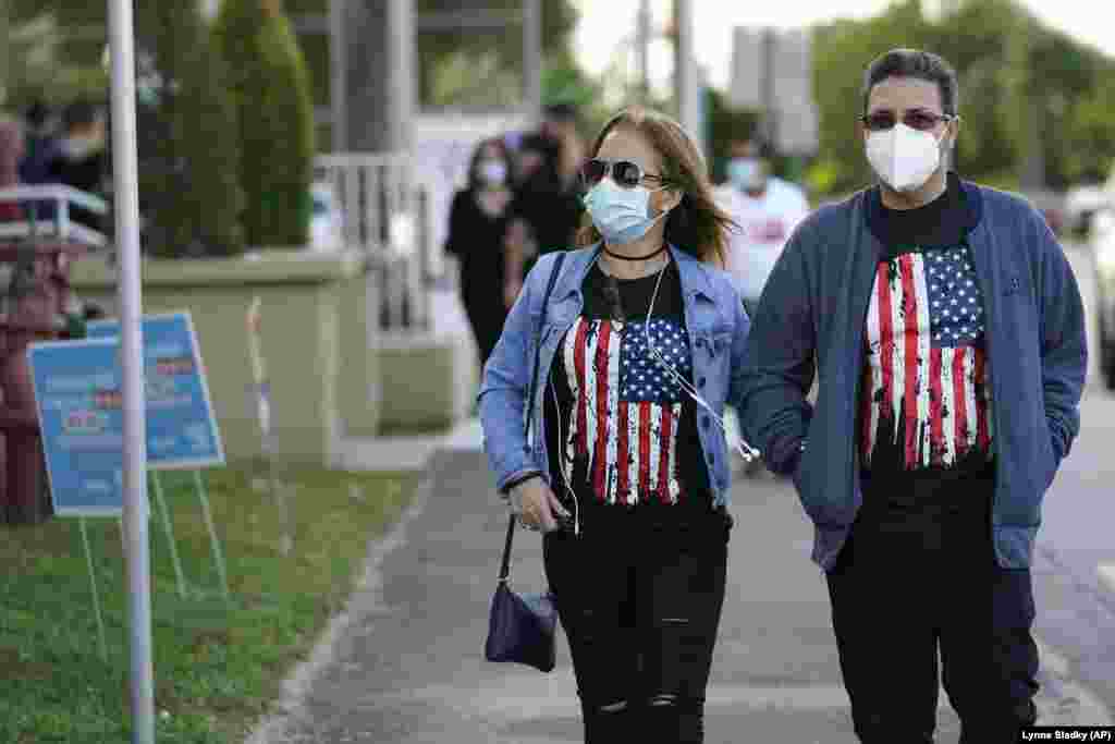 Леиди Перез, лево, и Едилио Галардо пристигнаа да гласаат во библиотеката Џон Ф. Кенеди во Хиалеа, Флорида.