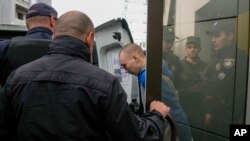 Sergentul rus Vadim Shishimarin e escortat de poliție după ce a fost condamnat la închisoare pe viață, Kiev, 23 mai 2022. 