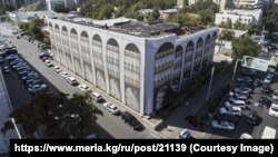 Өрттөнгөн имарат сүрөт тартылган тосмо менен жабылып коюлган.