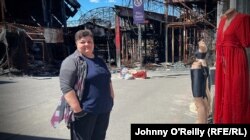 Ljudmjla Kirejeva bikiniüzlete előtt várja a vásárlókat