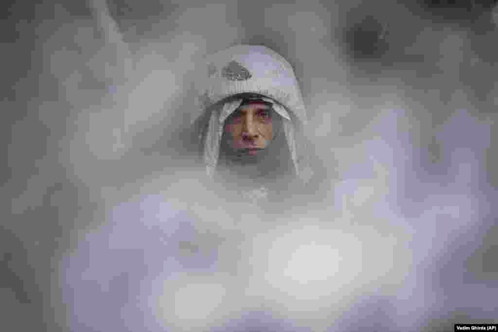 Një ushtar ukrainas me veshje kamuflazhi qëndron në një pozicion në vijën e frontit në rajonin e Luhanskut më 29 janar 2022. &nbsp;