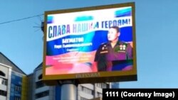 Украинадагы согушка тартылгандардын сүрөтү коюлган баннер. Москва. 2022-жыл. (Сүрөт "Азаттыкка" Вотсап аркылуу келди)