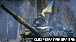 Un tanc ucrainean T-72 face manevre într-o lizieră din Donețk, estul Ucrainei, pe 18 ianuarie