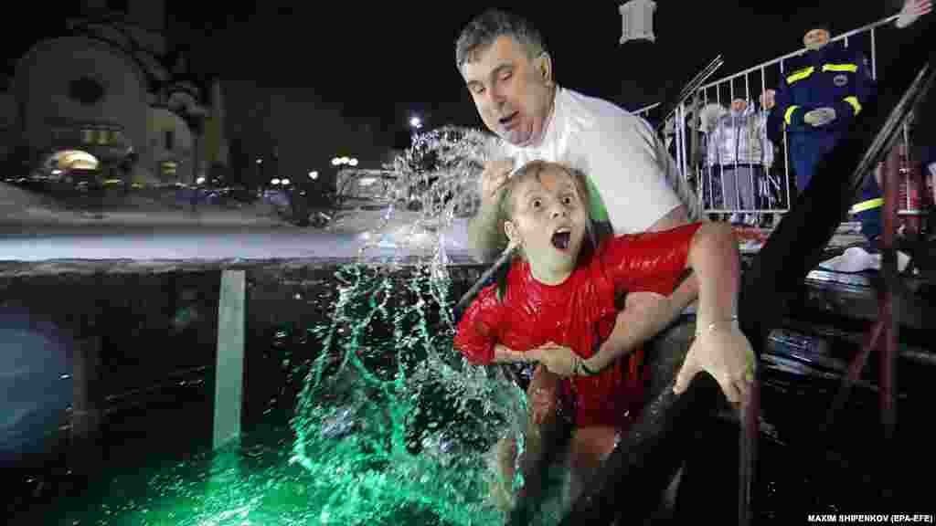 O fetiță reacționează la apa rece la Krasnogorsk, în apropiere de Moscova.