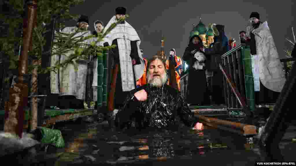 Un preot se scaldă în apopiere de Biserica Sfintei Treimi din&nbsp;Moscova.