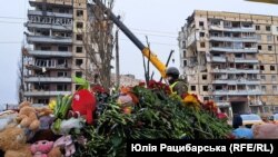 Люди приносять квіти та іграшки до місця ракетного удару по Дніпру. 17 січня 2023 року