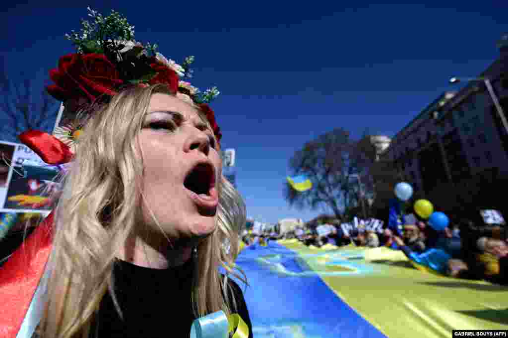 Një protestuese me një lule ukrainase në kokë proteston kundër luftës nga qyteti i Madridit.