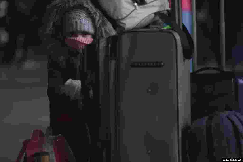 Një fëmijë i ulur në një valixhe, duke pritur në Kiev për të hipur në një tren drejt Lvivit, më 28 shkurt.