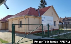 Nagyméretű EU-s projekt tábla az egyik üresen álló lakóotthon előtt a derecskei Mikes Kelemen utcában 2022. július 25-én