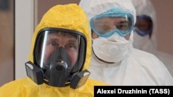 Президент России Владимир Путин в жёлтом защитном костюме в начале пандемии. 24 марта 2020 года