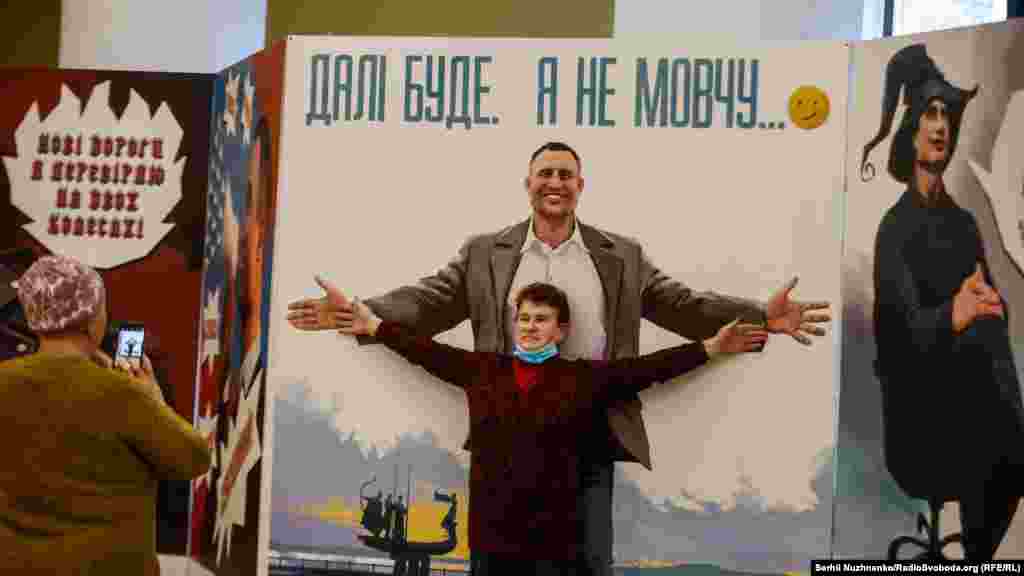 Жінка фотографується біля&nbsp;ілюстрованих&nbsp;самоіронічних цитат мера Києва Віталія Кличка