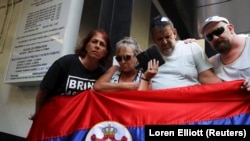 Pristalice Novaka Đokovića sa zastavom Srbije slušaju prenos sudskog ročišta u Melburnu, 16. januar 2022.