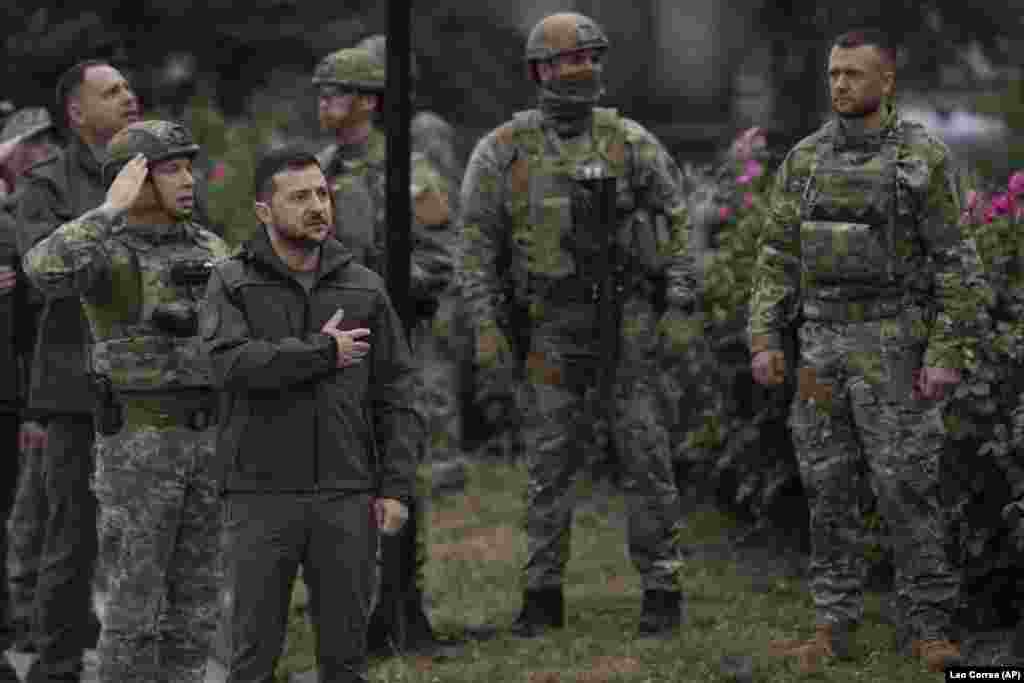 Ukrajinski predsednik Volodimir Zelenski pozdravlja zastavu svoje zemlje podignute ispred spaljene zgrade Gradske kuće u Izjumu 14. septembra. Zelenski je iznenadno posetio nedavno oslobođeni grad kako bi se sastao sa vojnicima i izrazio zahvalnost za njihove napore u ponovnom preuzimanju teritorija. &nbsp;