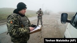 Український прикордонник перевіряє документи на пункті пропуску в Бердянську, 27 листопада 2018 року 
